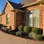 trimmed hedges and clean flowerbed outside of a home