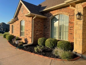 trimmed hedges and clean flowerbed outside of a home